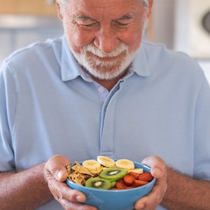 A man about to eat a healthy salad of fresh and dried fruits