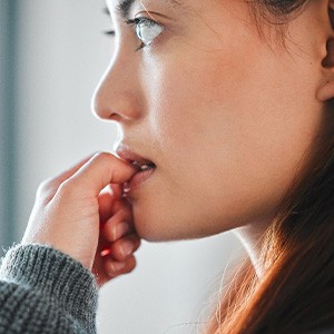 A woman nervously biting her fingernails