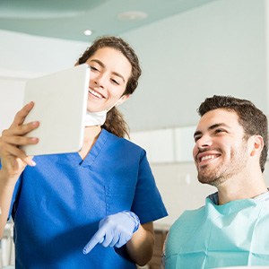 Dental hygienist goes over payment options on a tablet with patient