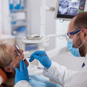 An older woman receiving a dental checkup from her dentist