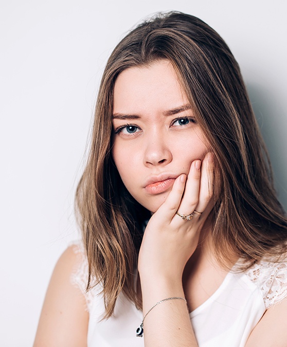 Closeup of person with toothache needing emergency dentist in Cambridge