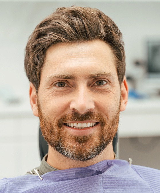 Woman in white shirt rubbing jaw in pain