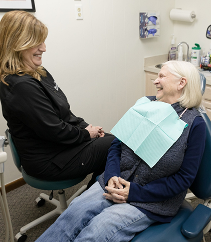 Dental team member speaking to dental patient in chair