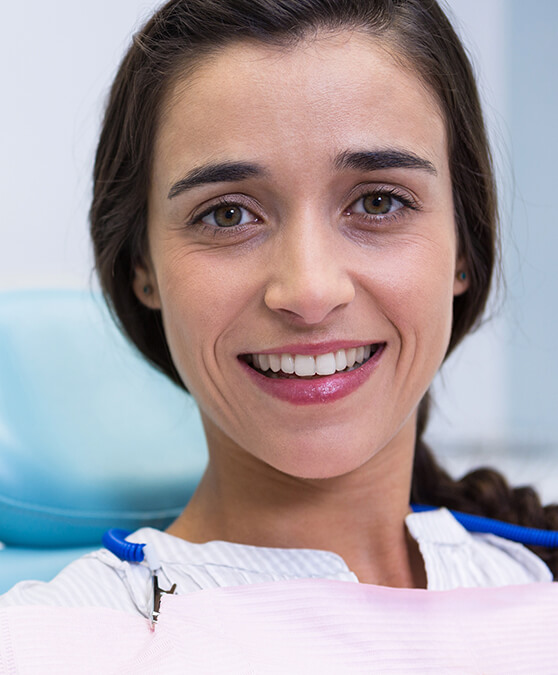 Woman sitting in dental chair and smiling