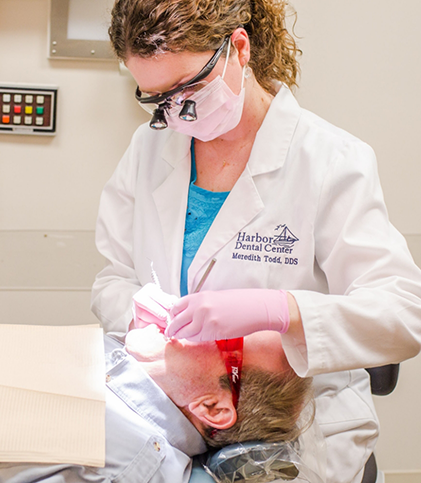 Female dentist with mask treating a patient