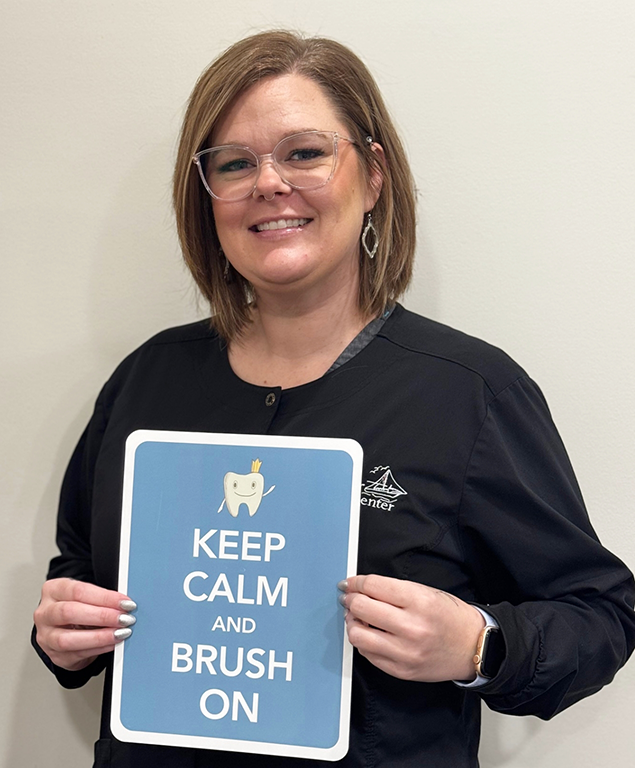 Kaycie holding sign that reads keep calm and brush on